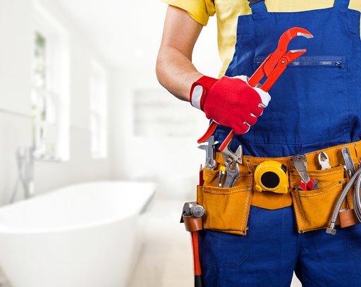 plumber with tool belt standing in bathroom